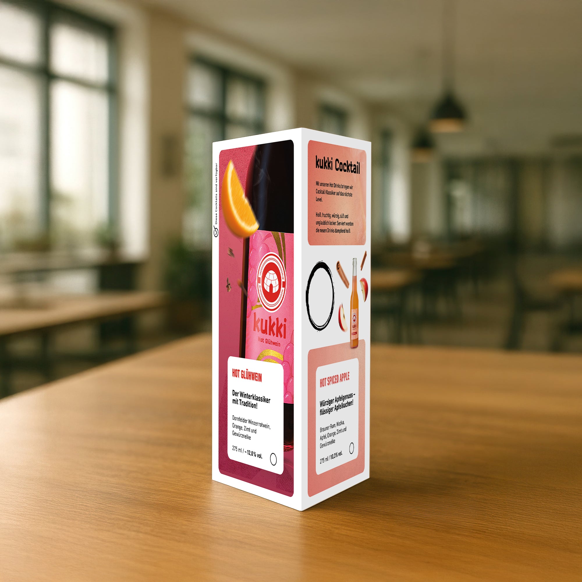 Dreieckiges Werbedisplay mit kukki Cocktail Hot Glühwein und Hot Spiced Apple auf Holztisch.