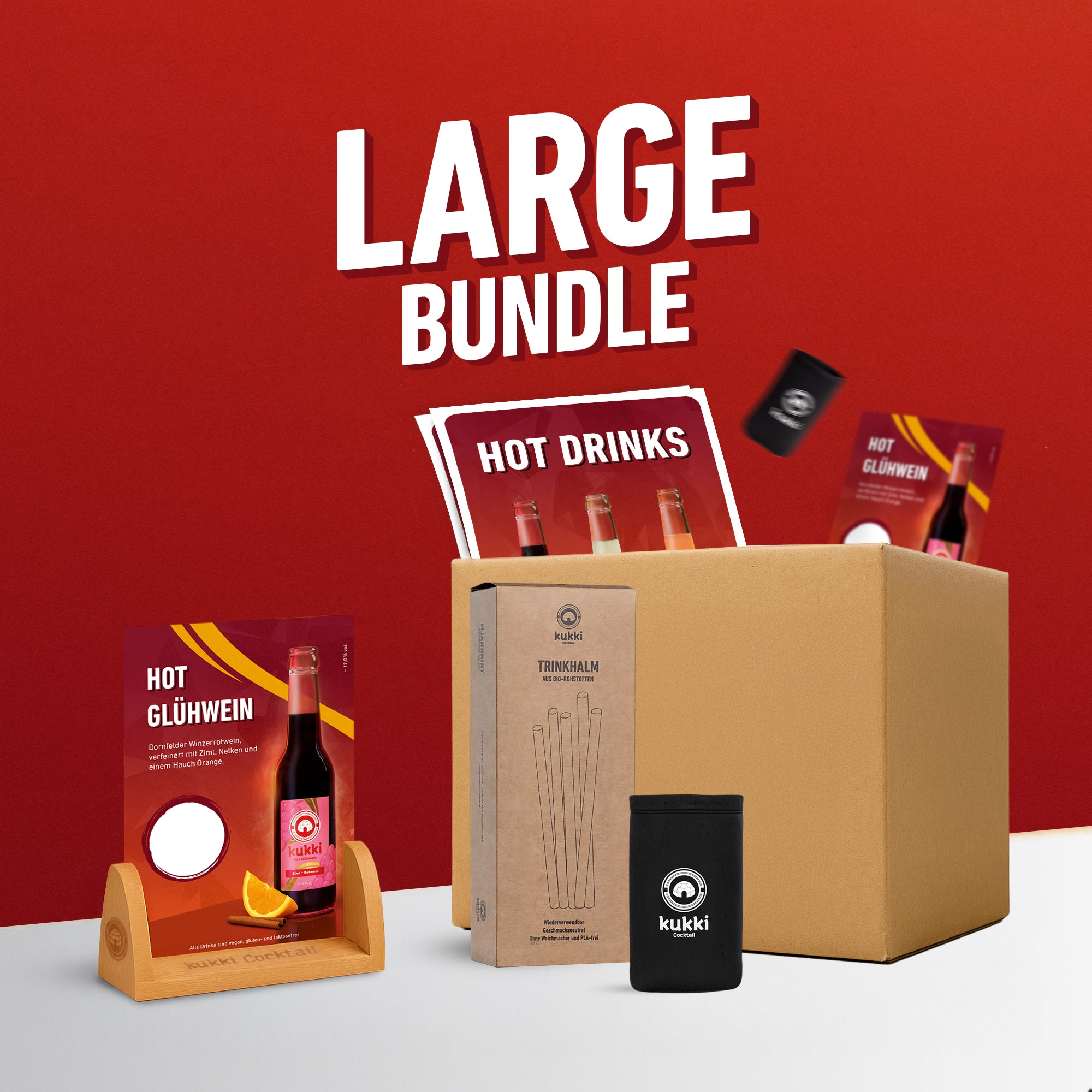 Großes Bundle mit gekühlten kukki Cocktails im Glühwein-Stil in Glasflaschen, Trinkhalmen und Hülle vor rotem Hintergrund.