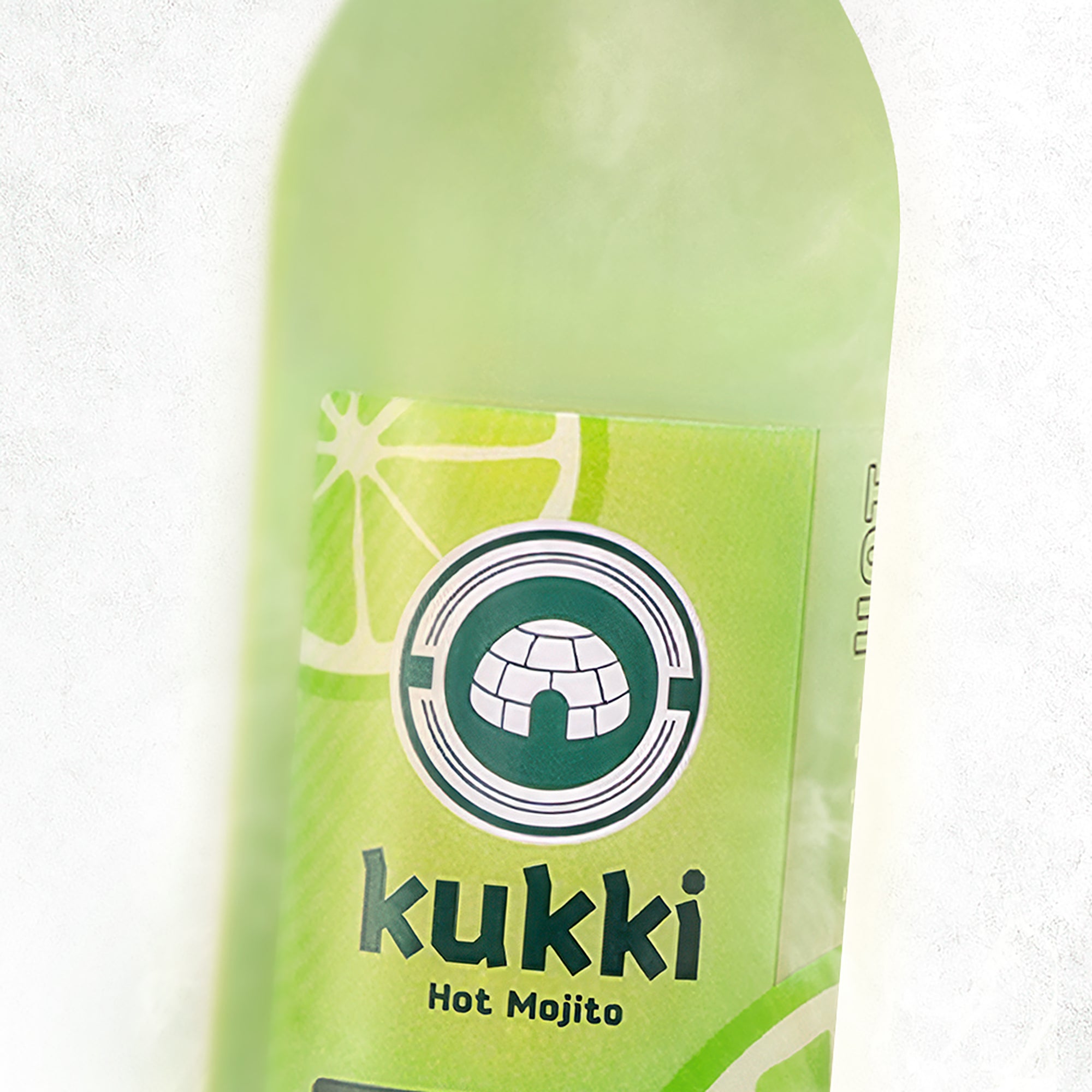 Grüne Glasflasche kukki Cocktail Mojito mit Limettenscheibe auf Etikett und Iglu-Logo vor weißem Hintergrund.