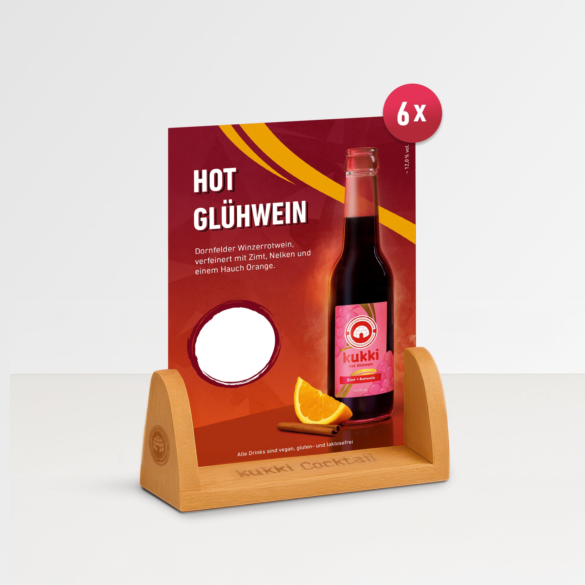 kukki Hot Glühwein Flasche mit Zimtstange und Orangenscheibe vor rotem Display auf Holzhalter