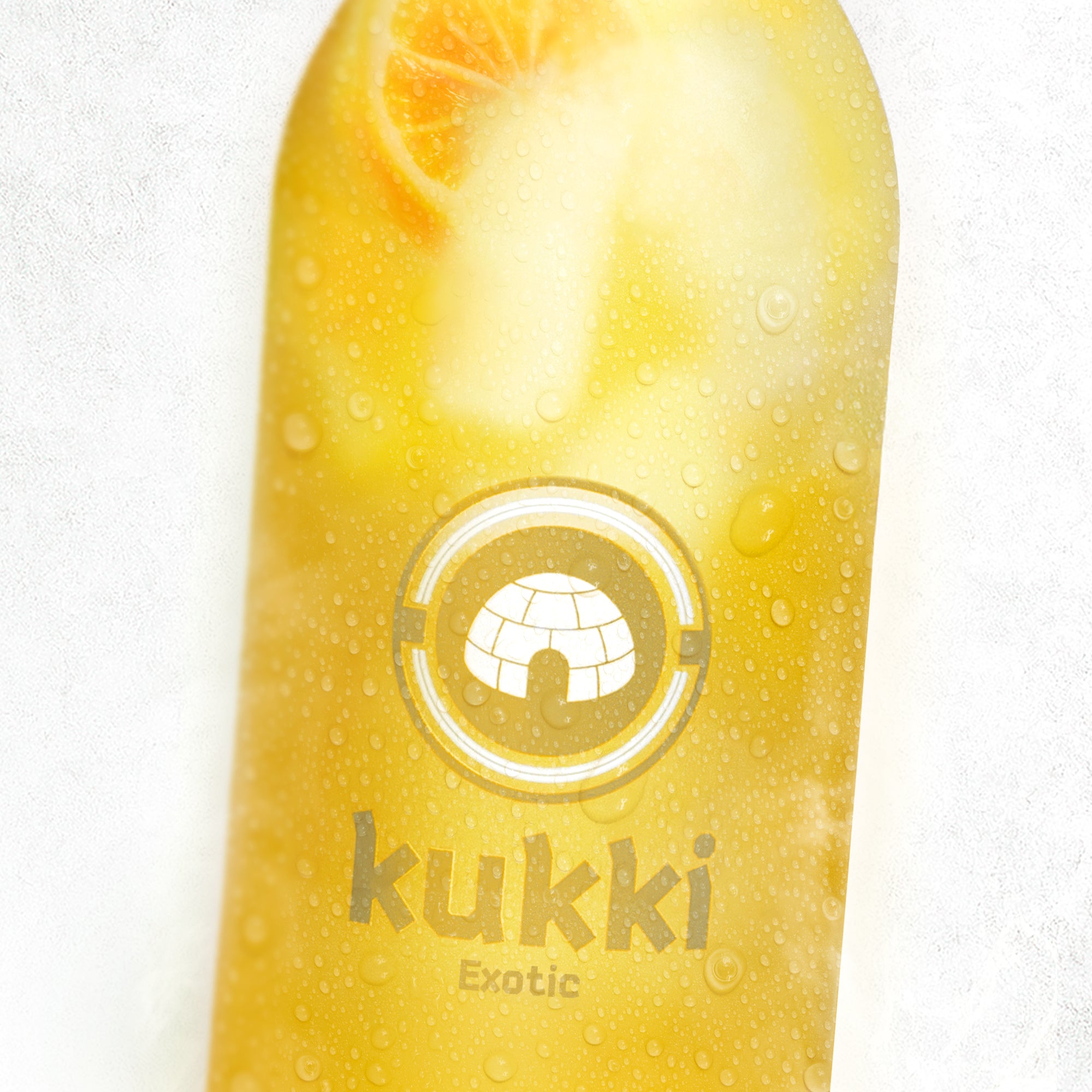 gelber kukki cocktail exotic in glasflasche mit orangenstück und kondensation