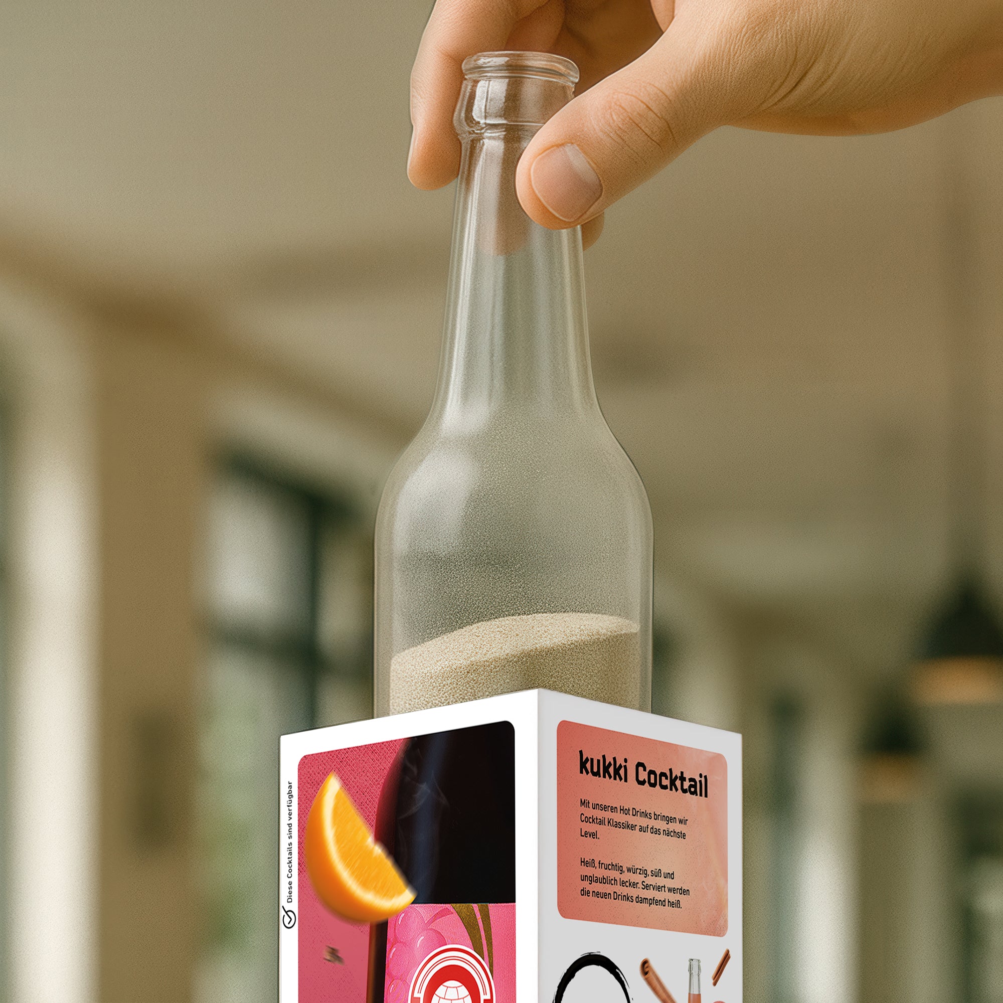 Hand hält gefrostete Glasflasche mit beigefarbenem Granulat auf kukki Cocktail Verpackung