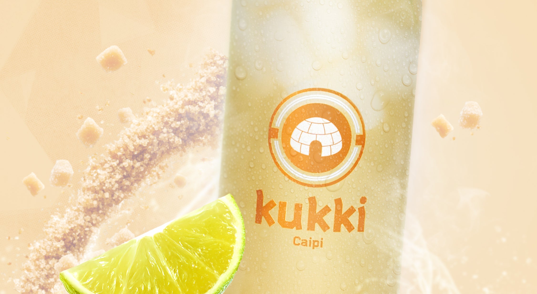 kukki Cocktail Caipi mit frischer Limettenscheibe und braunem Zucker vor beigem Hintergrund
