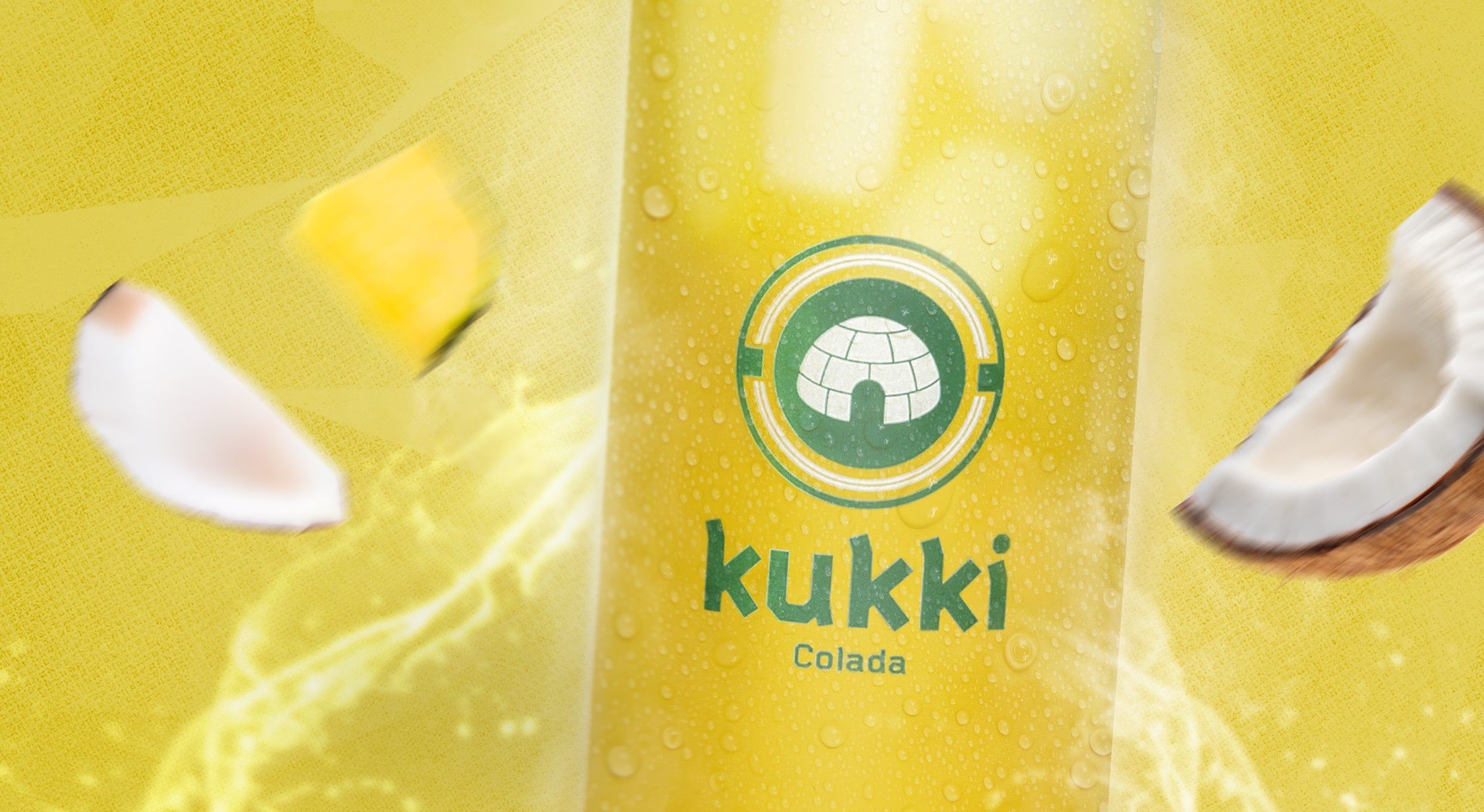 Großes Glas mit gelbem kukki Cocktail Colada, Eiswürfeln, Kondenswasser, Kokoshälften und Ananas auf gelbem Hintergrund.