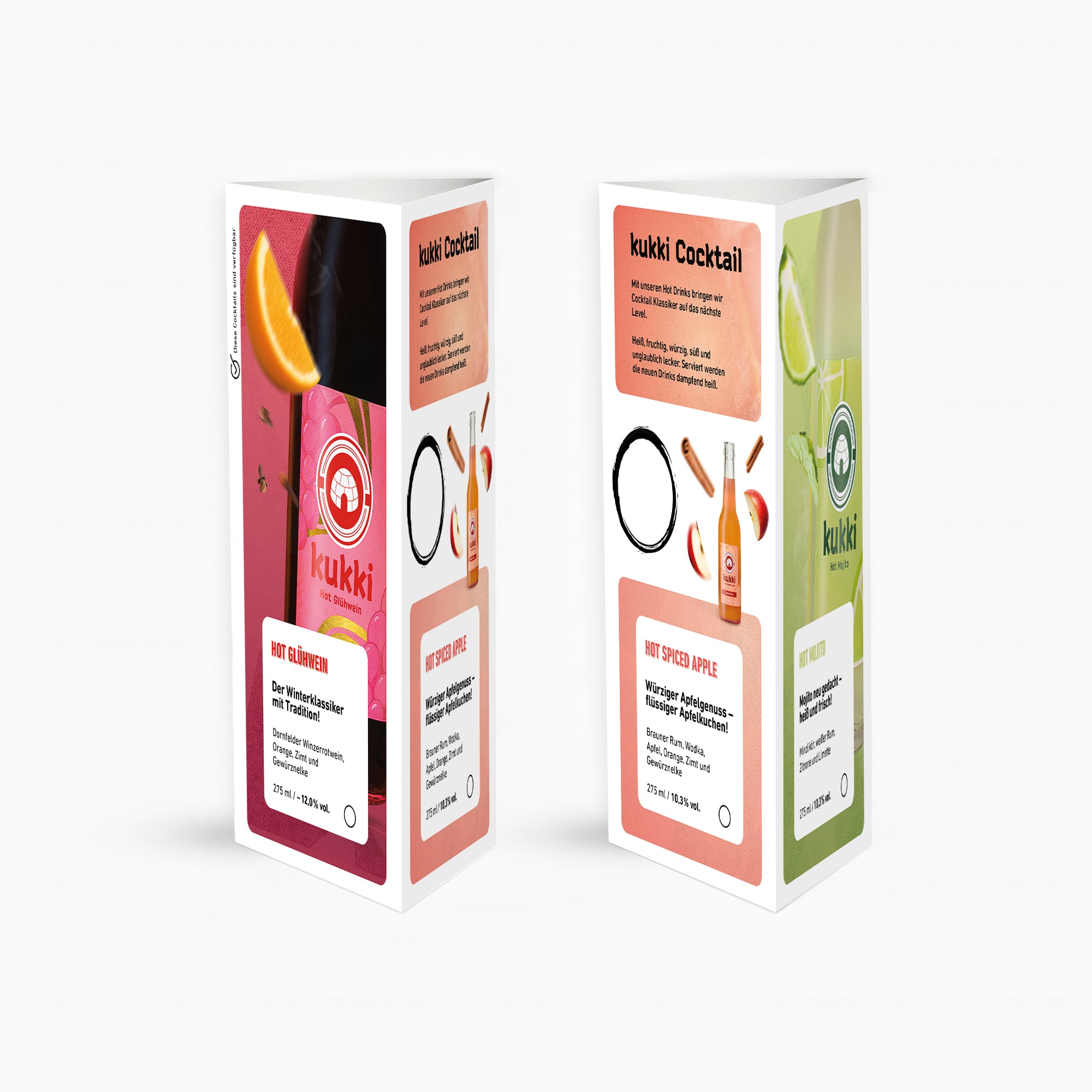 Zwei Kartons mit kukki Cocktails Hot Glühwein und Hot Spiced Apple, verziert mit Zimt, Orange und Gewürznelke.