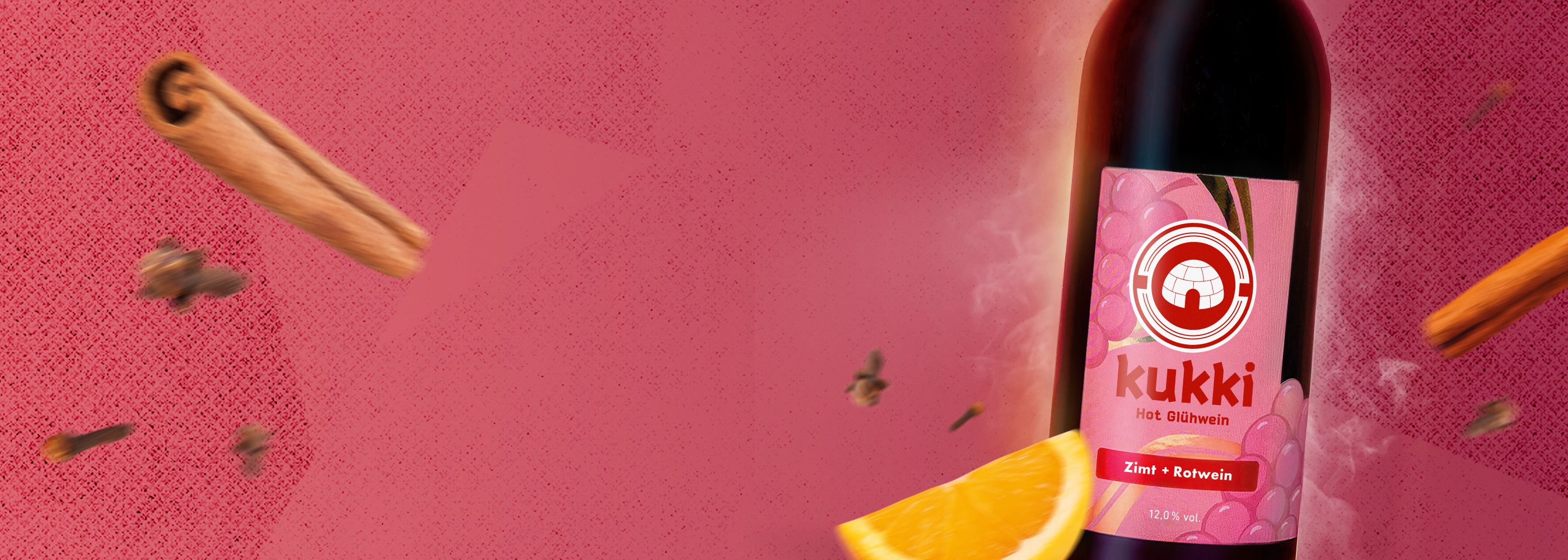 kukki Hot Glühwein in Glasflasche mit Zimt, Rotwein, Orangenstück und Gewürznelken vor rosa Hintergrund
