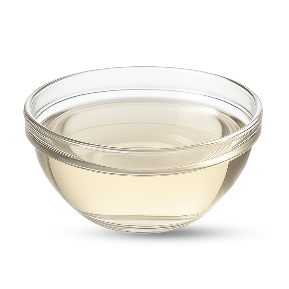 Rundes Glasschälchen mit hellgelblicher Flüssigkeit auf weißem Hintergrund